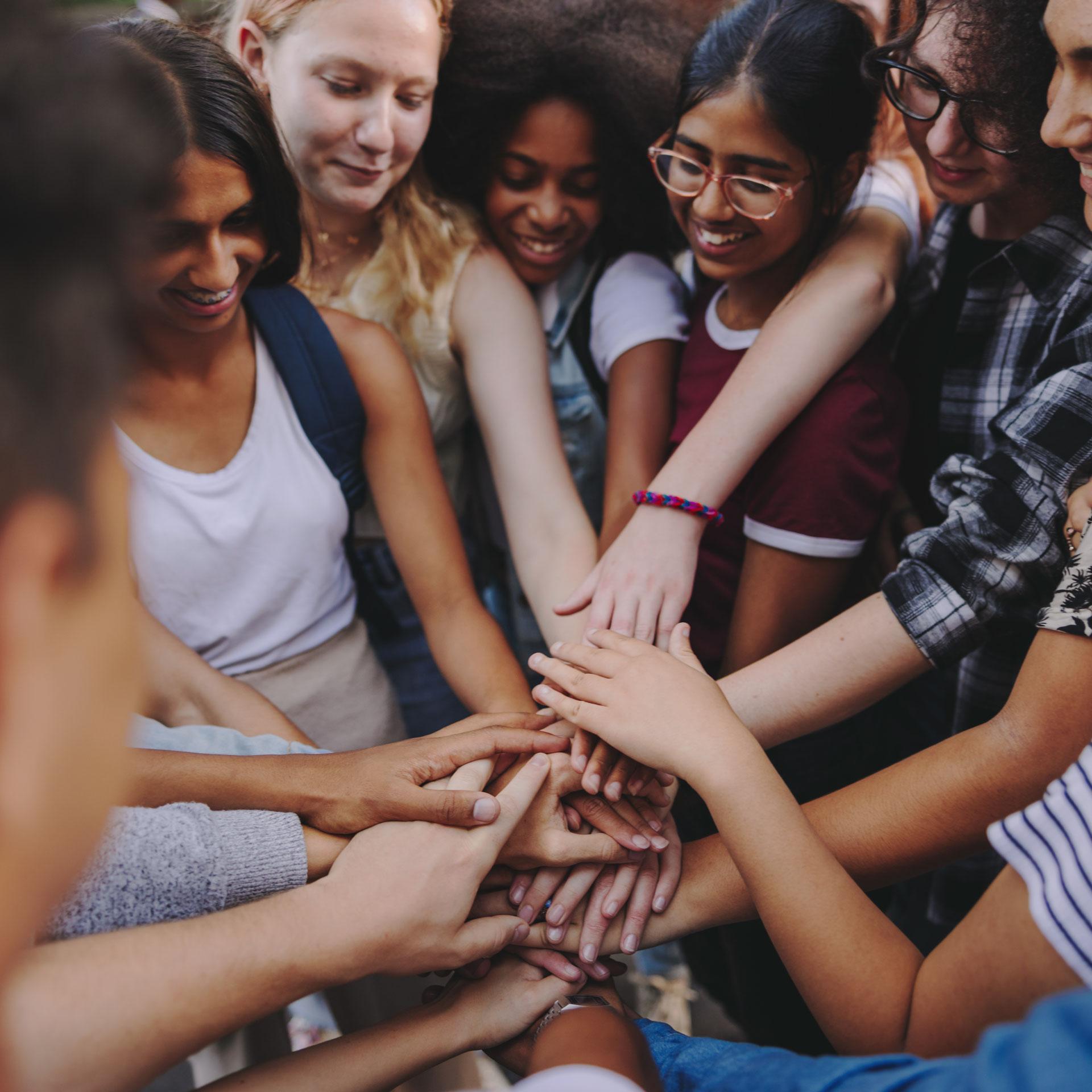 Diverse group of people joining hands